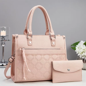 Set borsa a mano rosa con trama a rombi e pochette coordinata su scrivania bianca