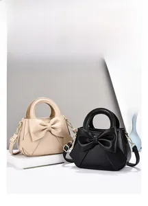 Detail of elegant handbags with oversized bow decoration and removable shoulder straps