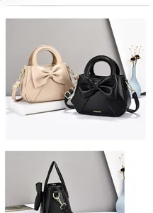 Detail view of fashion bow-tie handbags in beige and black with golden chain straps