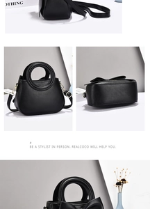 Detail of black leather handbag featuring round metal handles and large bow decoration