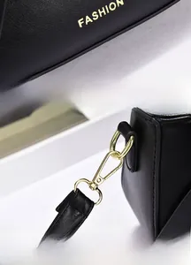 Close-up of golden FASHION logo and high-quality gold-plated metal hooks on black bag