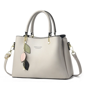 Elegant beige leather handbag with leaf charm and detachable strap for daily commuting