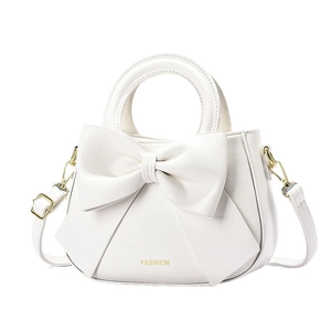 Elegant white crossbody handbag with large bow design and gold fashion text detailing