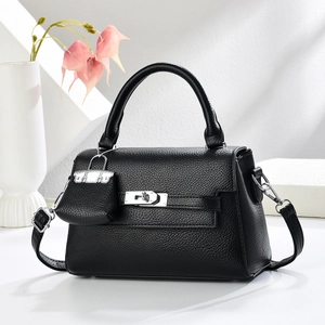 Close-up of black litchi grain leather handbag with silver clasp and mini coin purse