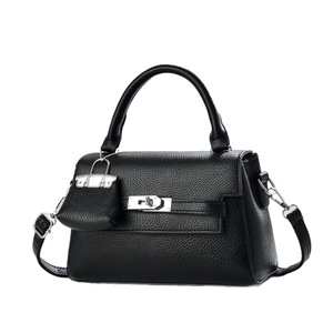 Fashionable black pebbled leather handbag with metal turn-lock and shoulder strap for women