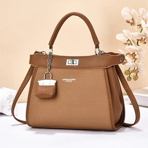 Sac à main en cuir marron avec poignée et bandoulière sur table blanche élégante