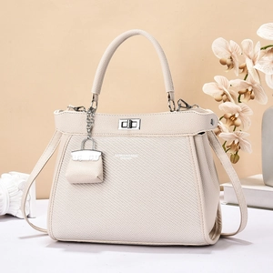 Sac bandoulière en cuir ivoire avec panneau texturé, fermoir argenté et mini pendentif