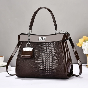 Dark brown faux crocodile leather handbag with gold twist lock and mini charm accessory
