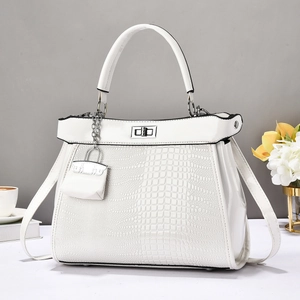 White crocodile-embossed Kelly-style handbag with metal turn-lock and small charm