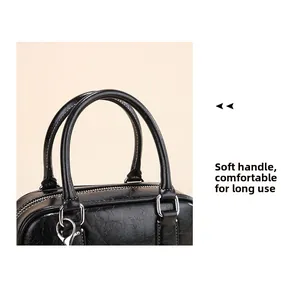Detail of soft leather dual handles on black pillow bag with neat stitching and silver hardware