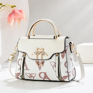 Elegant white crossbody bag with floral pattern and gold swan clasp on minimal background