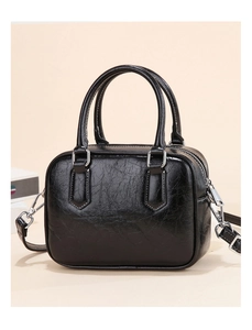 Detail of black glossy crinkle texture Boston bag with silver buckles and handles