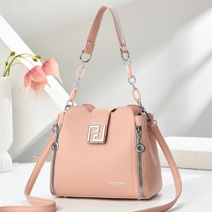 Detailed view of pink pebble leather handbag with silver square buckle and metal chain handle