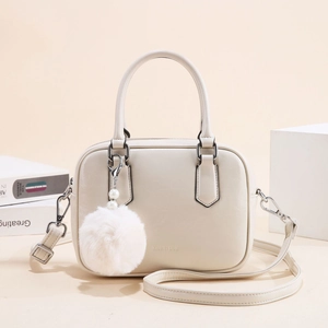 Minimalist off-white square crossbody bag with top handle and pearl fur ball charm