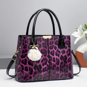 Purple leopard print handbag with glossy black handles and fluffy pearl charm accessories