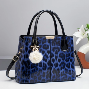 Navy blue leopard print handbag with glossy finish and plush bow charm detail