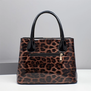 Glossy leopard print handbag detail showing black handles and back zipper pocket