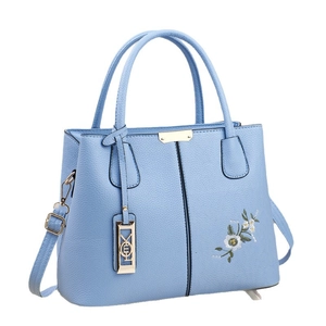 Light blue pebbled leather handbag with floral embroidery and adjustable strap