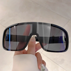 Detail of matte black oversized sports goggles with dark gray translucent lens for cycling
