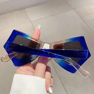 Macro shot of oversized butterfly frame sunglasses with gradient blue to champagne tint