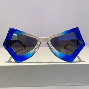 Close-up of butterfly sunglasses featuring blue-white gradient frames on a white pedestal