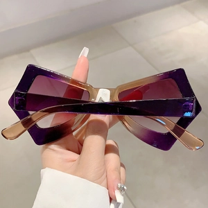 Close-up of trendy oversized butterfly sunglasses with purple gradient frame