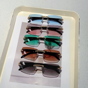 Detail of rimless sunglasses with metal C-hinges and varied color gradient lenses