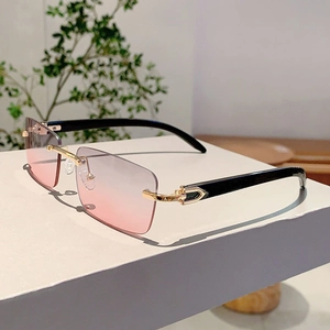 Detail of rimless rectangle sunglasses with wood grain temples and C-decor metal hinge