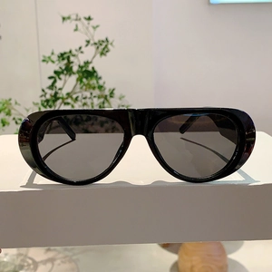 Close-up of thick black rectangular frames and gray polarized lenses on a white pedestal