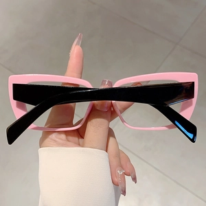 Close-up of pink cat-eye frames and black wide temples on stylish anti-blue light glasses
