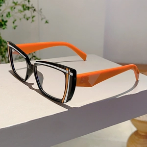 Detailed close-up of two-tone eyewear frame with black front and bright orange temples