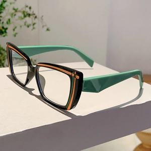 Detail of color-block glasses frame with black front and vibrant orange line accents