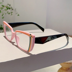 Detail of pink and black eyewear frame showing orange and green striped accents on temple