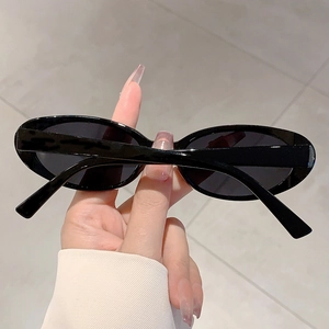 Détail de lunettes de soleil ovales noires rétro avec monture épaisse de style Y2K