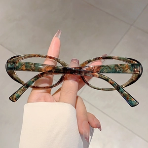 Détail de la monture de lunettes ovale avec texture marbrée verte et orange vintage