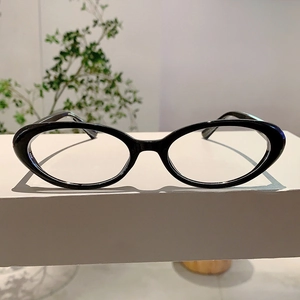 Détail de lunettes vintage œil de chat noires sur un présentoir minimaliste