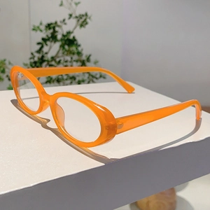 Vue détaillée d'une monture de lunettes ovale orange vif transparente sur support blanc