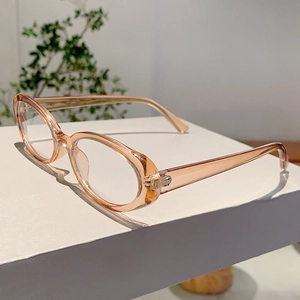 Détail de la monture ovale transparente champagne sur un présentoir minimaliste