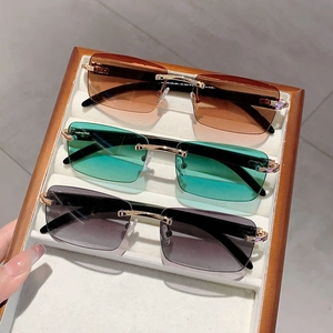 Three pairs of rimless sunglasses with gradient lenses and faux wood temples in a box