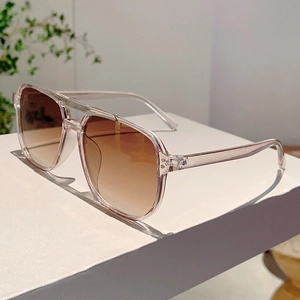 Detail of pink transparent acetate pilot sunglasses with brown gradient lenses and dual bridge