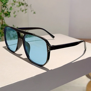Close-up of black square frame sunglasses with silver rivets and light blue lenses