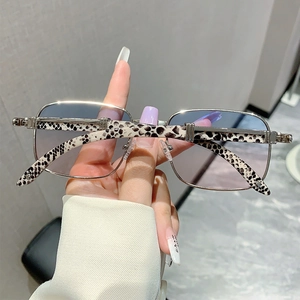 Détails des lunettes carrées dorées avec verres dégradés bleu-rose et branches léopard