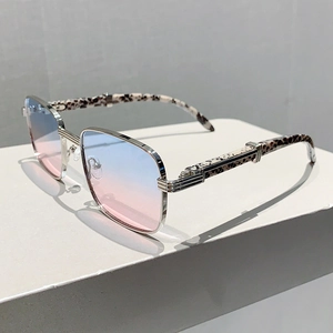 Gros plan sur des lunettes de soleil carrées avec verres dégradés bleu-rose et branches léopard