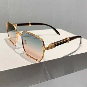 Détail de lunettes de soleil carrées avec monture dorée et branches à grain de bois