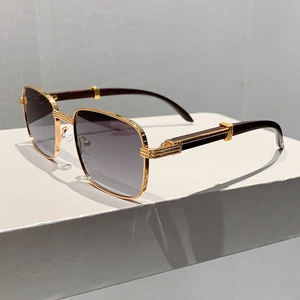 Détail d'une monture carrée en métal doré et branches en bois sombre sur lunettes dégradées