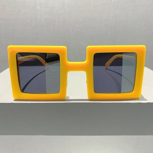 Detail of trendy yellow chunky square sunglasses with dark grey lenses on display