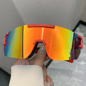 Detail of red paint-splatter frame on wrap-around sports sunglasses with orange lenses