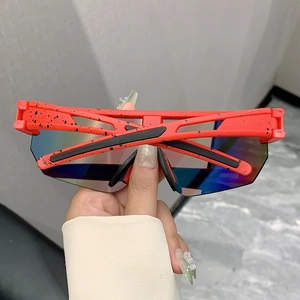 Detail of red splattered cycling sunglasses with oversized purple gradient lenses