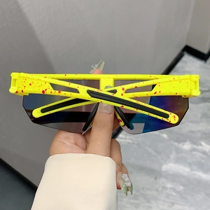 Detail of yellow and red paint-splatter frame with blue gradient lens on sport sunglasses