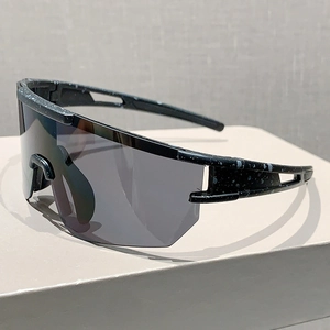 Detail of oversized cycling sunglasses with black frame and white splatter pattern